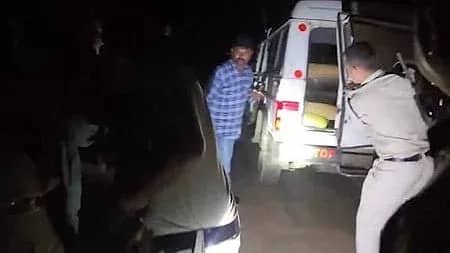 رات کے وقت ایک پولیس اہلکار گاڑی کا دروازہ کھول رہا ہے، جبکہ ایک شخص کھڑا ہے۔