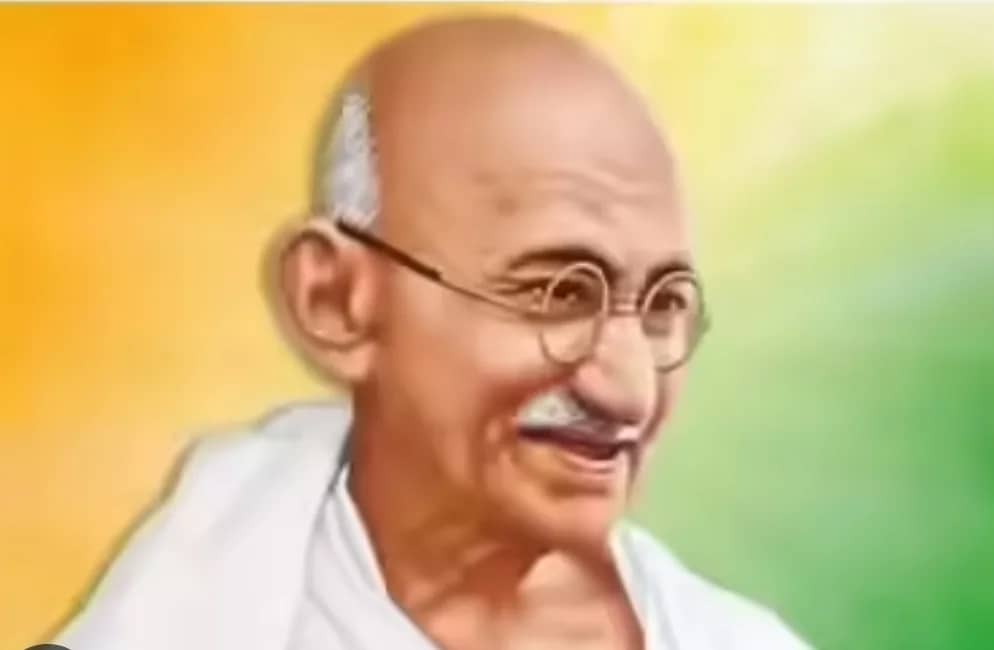 مہاتما گاندھی کا ایک کارٹون، جس میں وہ مسکرا رہے ہیں اور ان کے پیچھے نارنجی اور سبز رنگ کا پس منظر ہے۔