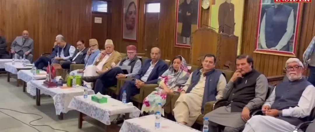 ایک کمرے میں میزوں کے پیچھے بیٹھے ہوئے مردوں اور عورتوں کا ایک گروپ۔