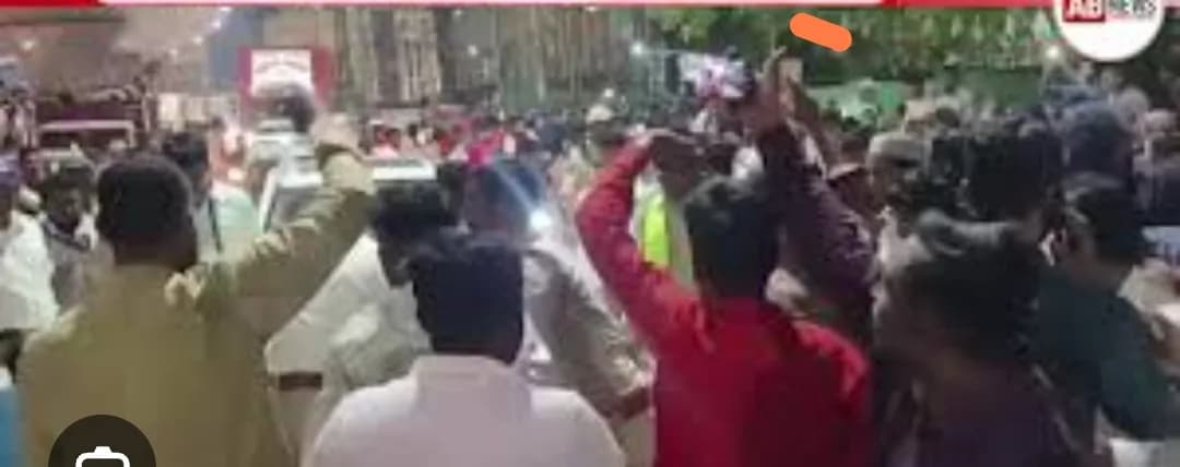لوگوں کا ایک ہجوم سڑک پر چل رہا ہے، کچھ لوگ اپنے ہاتھ ہوا میں اٹھائے ہوئے ہیں۔