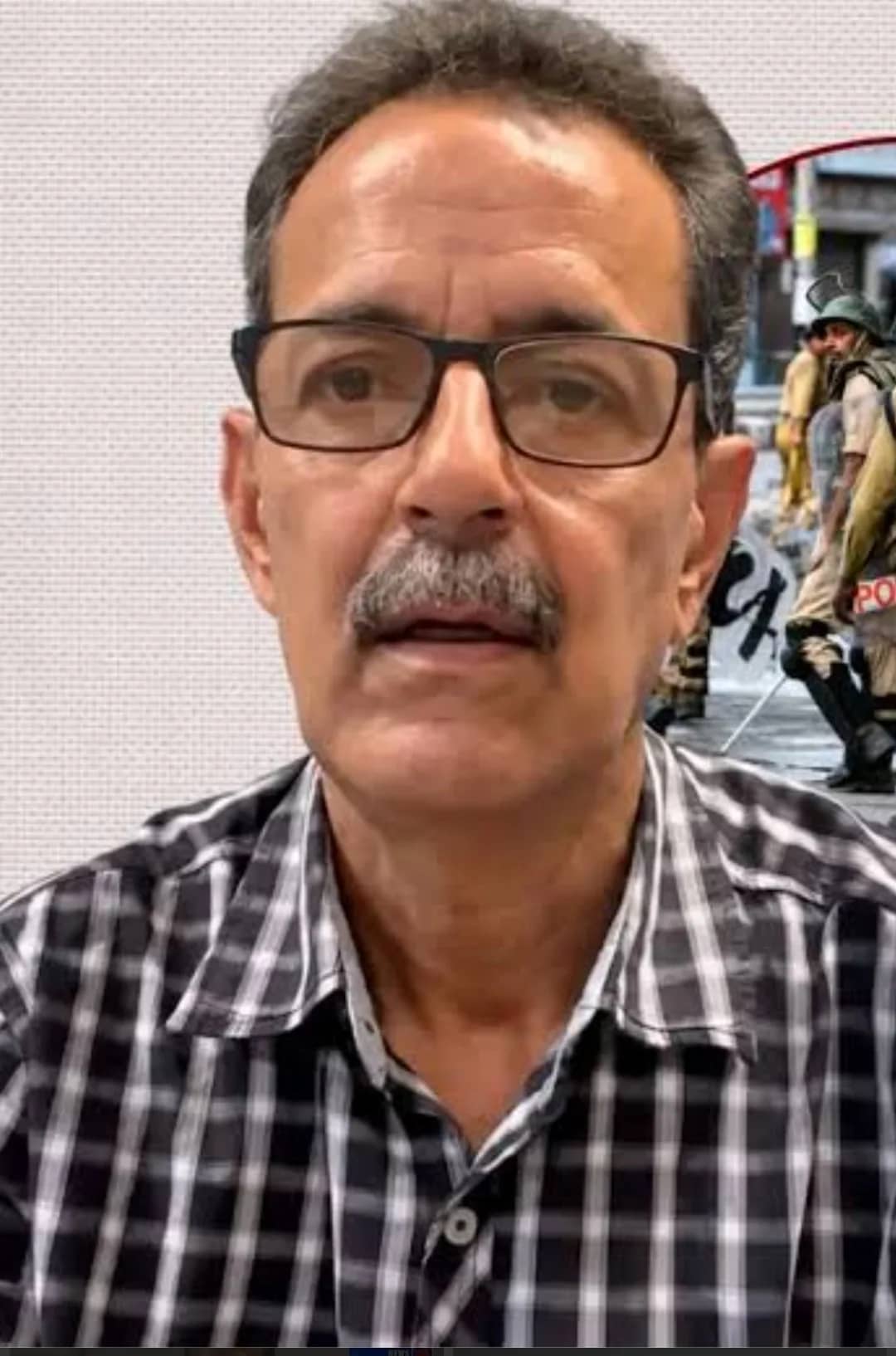 ایک شخص کالی اور سفید چیک والی قمیض پہنے ہوئے کی تصویر۔
