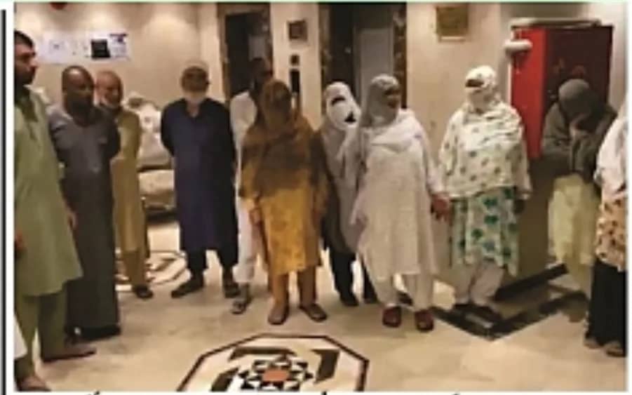 ایک کمرے میں مردوں اور عورتوں کا ایک گروپ کھڑا ہے۔