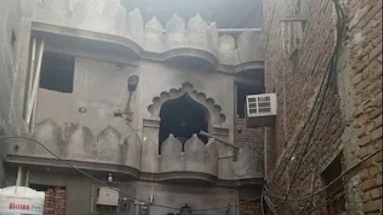 پرانی عمارت کا محرابی دروازہ، بالائی بالکونی اور قریب اینٹوں کی دیوار