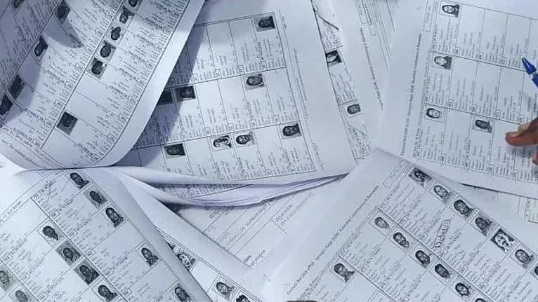 ایک میز پر بہت سے انتخابی بیلٹ پیپرز کا ڈھیر لگا ہوا ہے۔